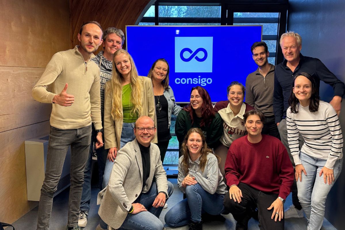 Team Consigo Online Marketing, groep mensen, staand en een aantal op de knieën voor een scherm met logo Consigo.